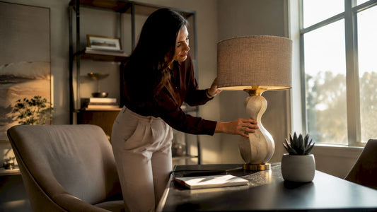 Woman adjusting sculptural lamp in living room corner