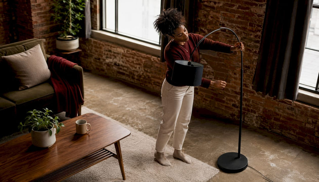 Woman adjusting arc floor lamp in living room