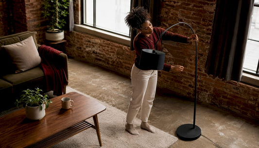 Woman adjusting arc floor lamp in living room