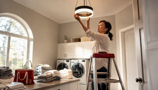 Woman installing flush-mount ceiling light in laundry room