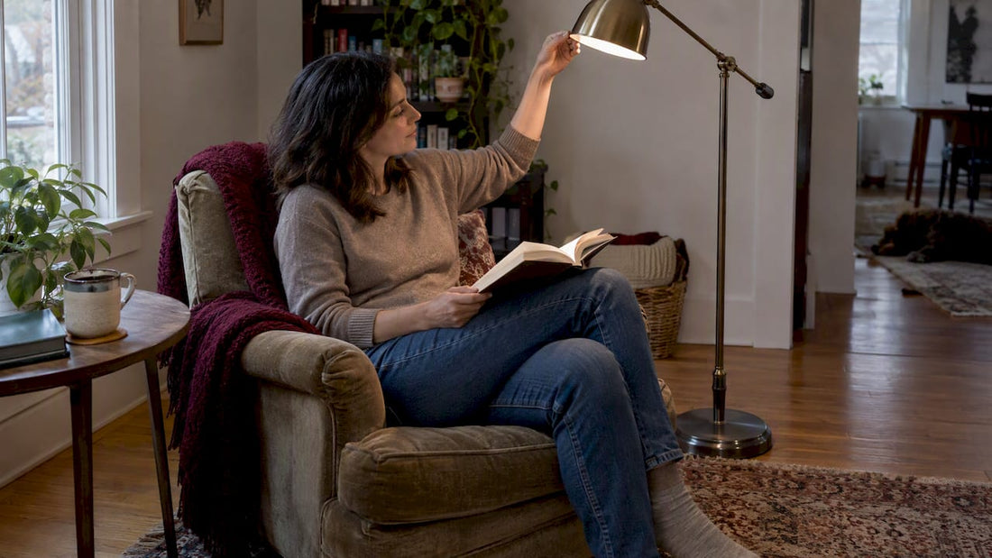Woman reading beside adjustable floor lamp
